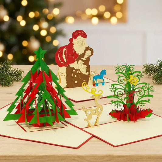 Drei geöffnete LINPopUp Pop-Up-Weihnachtskarten mit modernem Tannenbaum, Weihnachtsmann mit Gabensack und Weihnachtsbaum mit Rentier auf hellem Holz vor warmen Weihnachtslichtern
