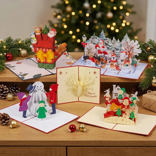 Fünf Pop-Up-Karten des Sets Fröhliche Weihnachtszeit stehen getrennt auf einem Sideboard mit Tannengrün und Weihnachtslichtern