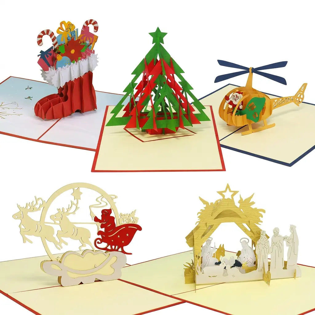 Fünf geöffnete Pop-Up-Weihnachtskarten mit Tannenbaum, Nikolausstiefel, Rentierschlitten, Krippe und gelbem Helikopter vor weißem Hintergrund.