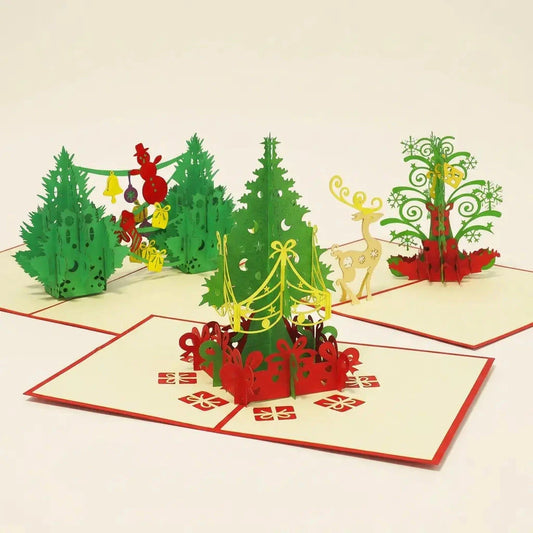Drei geöffnete LINPopUp Pop-Up-Weihnachtskarten im Set Tannenbaumfreude: zwei geschmückte Weihnachtsbäume, Tannenbaum mit Geschenken und filigraner Weihnachtsbaum mit gelbem Rentier