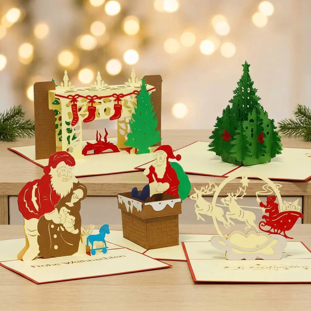 Fünf geöffnete Pop-Up-Weihnachtskarten des Sets Bescherungszauber auf einem Holz-Sideboard mit Tannengrün und warmen Weihnachtslichtern