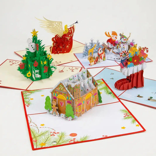 Fünf geöffnete LINPopUp 3D Pop-Up-Weihnachtskarten im Set Weihnachtsvielfalt: Tannenbaum, Weihnachtsengel, Nikolausstiefel, Lebkuchenhaus und Schneemänner auf Ski