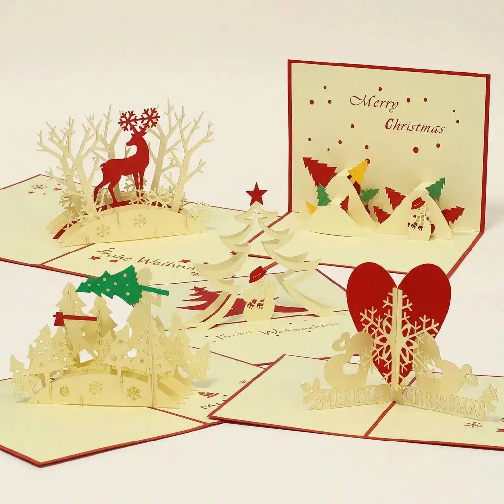 Fünf geöffnete LINPopUp Pop-Up-Weihnachtskarten im Set Winterwald: Rentier im Winterwald, Tannenbaumfällen, Schneemann-Landschaft, Schneemann mit Tannenbaum und Schneeflocke mit rotem Herz