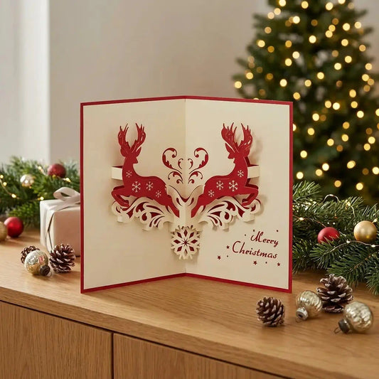 Aufgestellte Hirsch-Pop-Up-Weihnachtskarte auf einem Sideboard mit Tannengrün, roten und goldenen Kugeln und warmen Lichtern