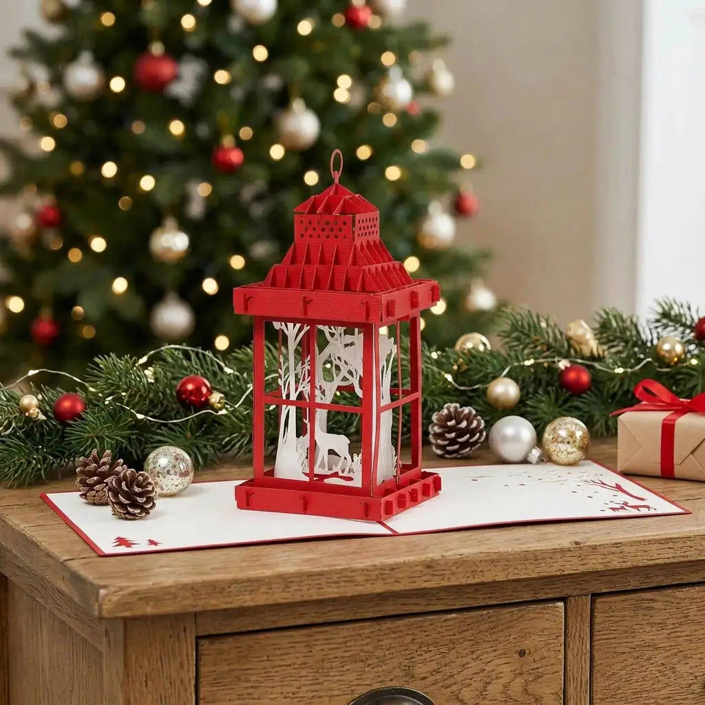 Offene rote Papierlaternen-Karte auf einem Sideboard mit Tannengrün, Weihnachtskugeln und warmen Lichtern